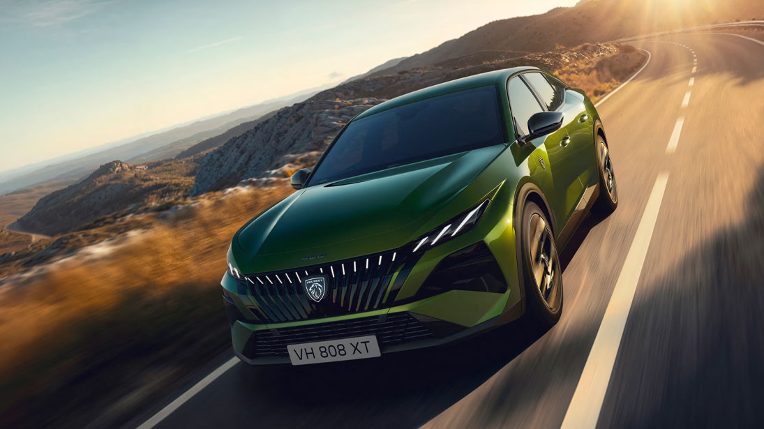 Peugeot 408 - kadr przedstawiający najnowszy model samochodu na tle drogi w górskim krajobrazie