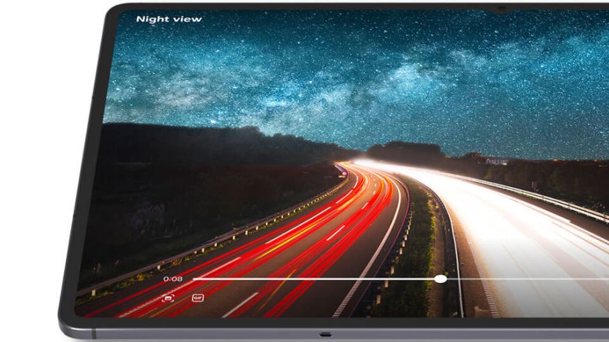 Tablet Samsung Galaxy Tab S11, z prawej strony ucięty, na ekranie droga nocą, rozmyte światła (długa ekspozycja) .