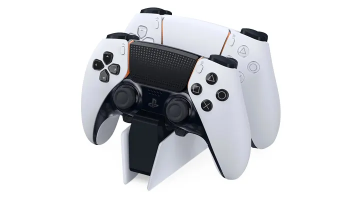 Na białym tle stojak z dwoma białymi kontrolerami do gier PlayStation z czarnymi akcentami.