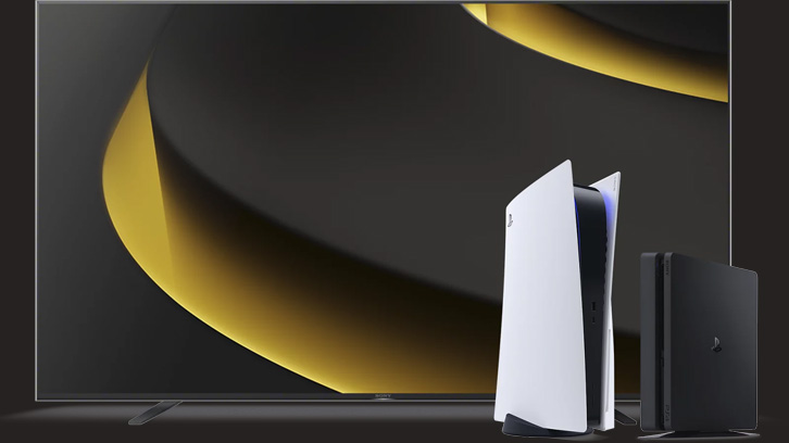 Na obrazie widoczny jest telewizor z abstrakcyjnym, złotym wzorem na ekranie, obok którego stoją biała konsola PlayStation 5 i czarna konsola PlayStation.