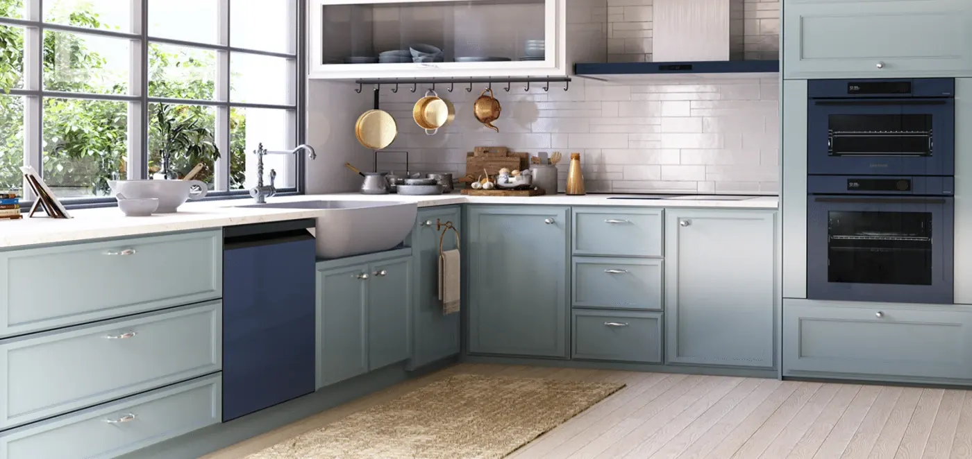 Jasna kuchnia z niebieskimi szafkami, drewnianą podłogą i oknem. Widoczne garnki, naczynia, zlew oraz piekarnik.