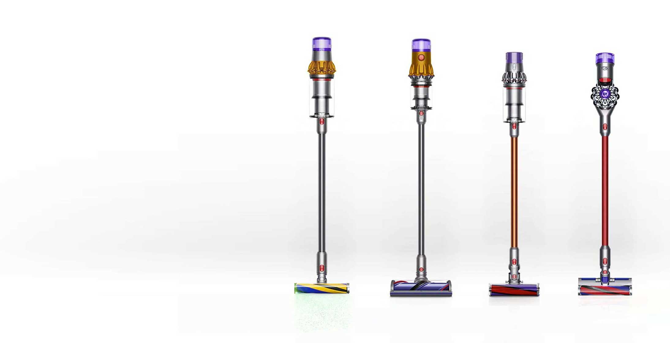Cztery odkurzacze pionowe Dyson w kolorach: srebrnym, pomarańczowym i czerwonym, na białym tle.