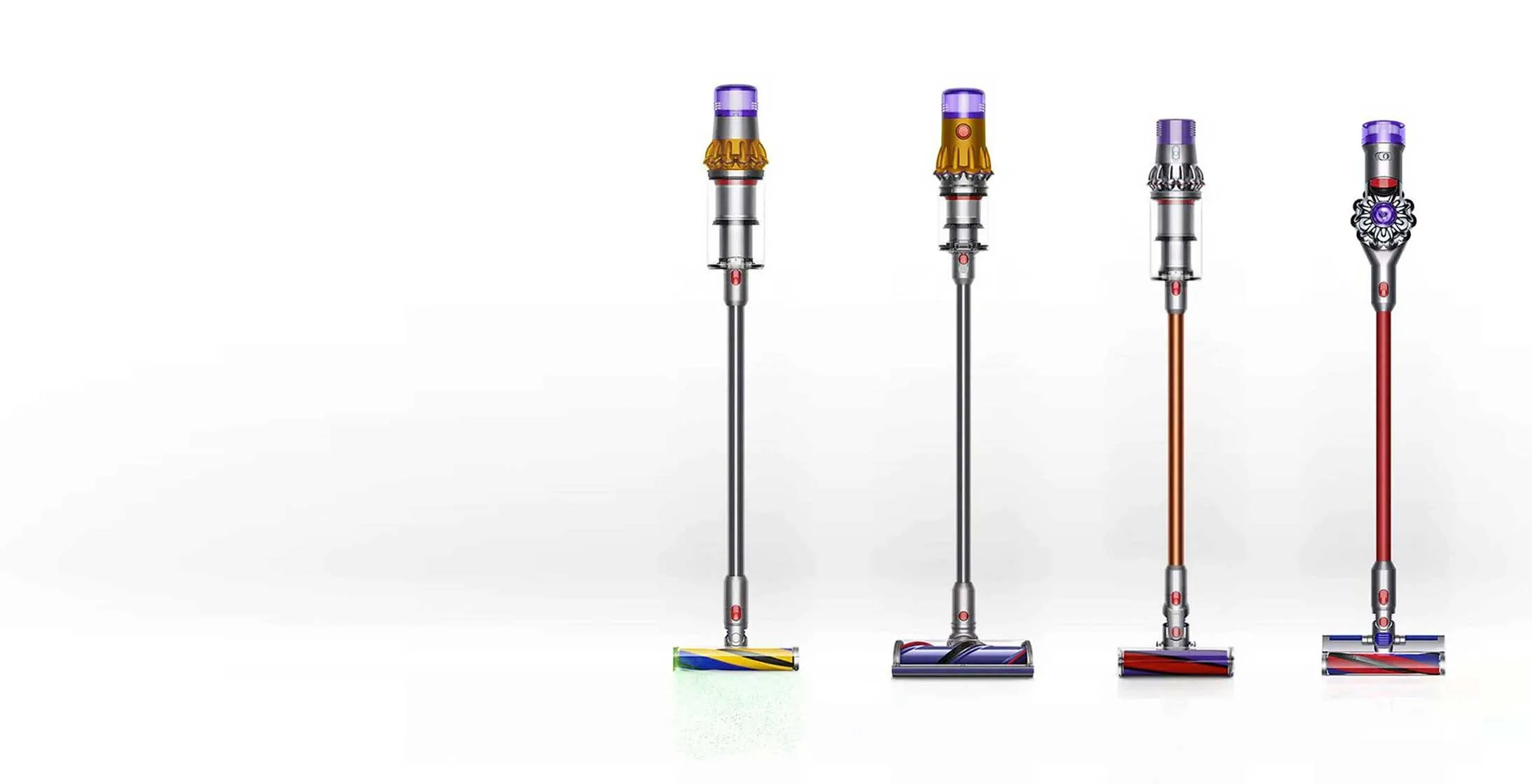 Cztery odkurzacze pionowe Dyson w kolorach: srebrnym, pomarańczowym i czerwonym, na białym tle.