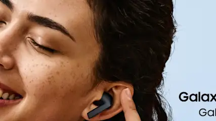 Portret uśmiechniętej kobiety ze słuchawką Samsung Galaxy Buds3 FE w uchu.