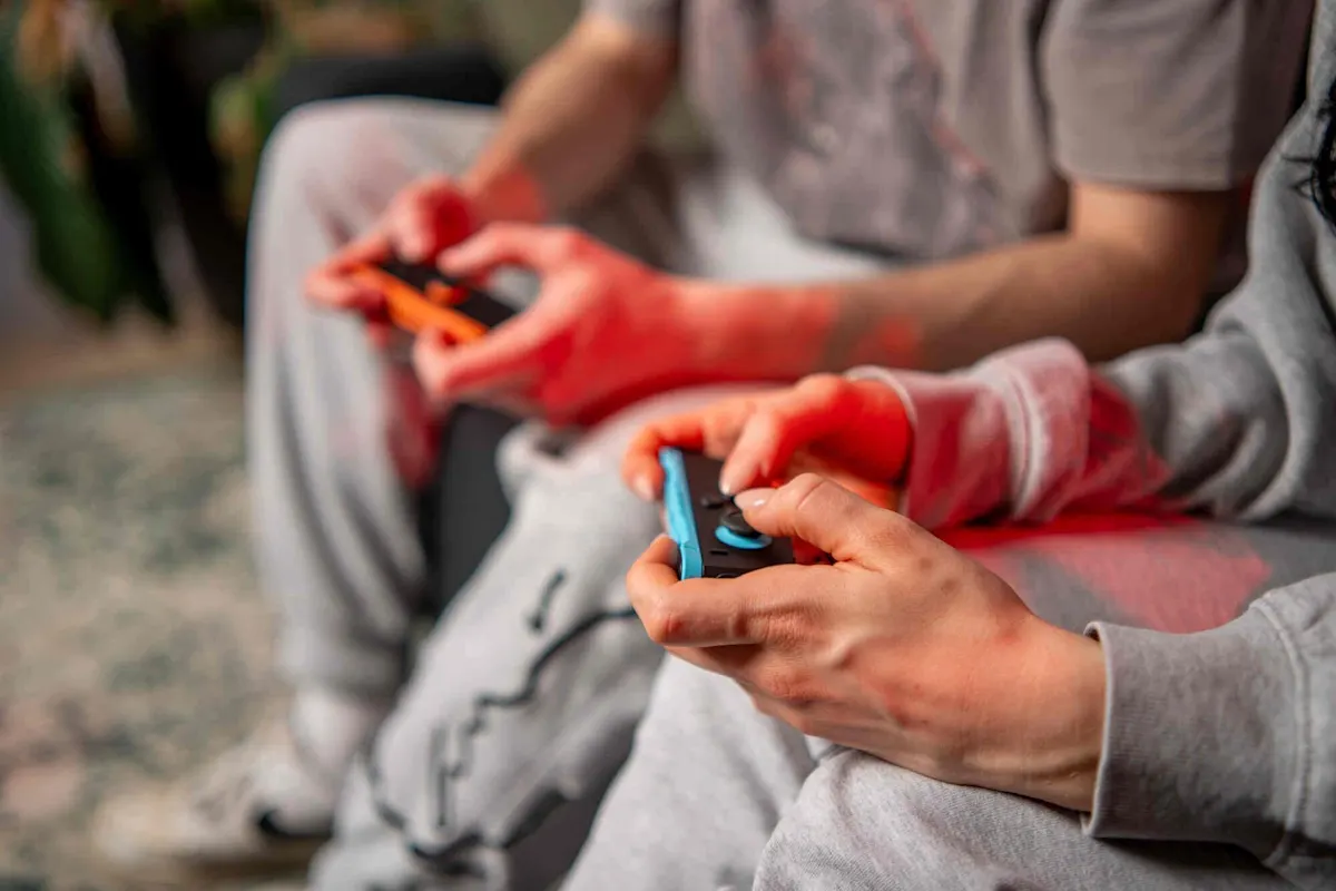Gros plan sur deux personnes tenant des manettes Joy-Con de la Nintendo Switch 2 dans leurs mains.