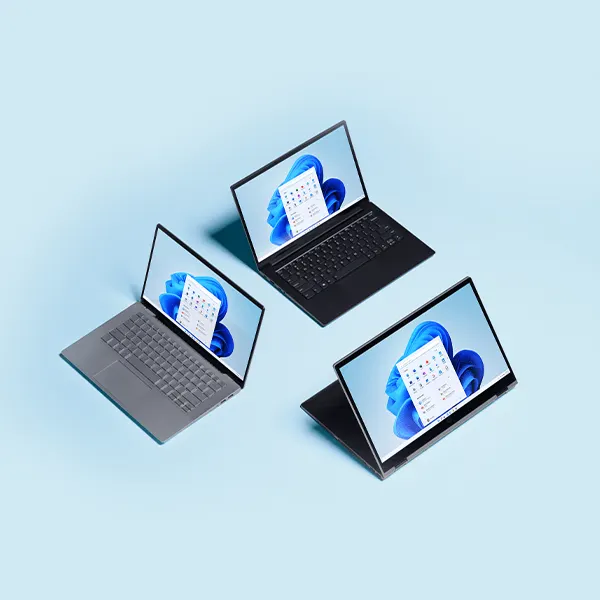 Des ordinateurs portables ouverts en noir et argent et un convertible ouvert avec Windows 11 sur fond bleu clair.