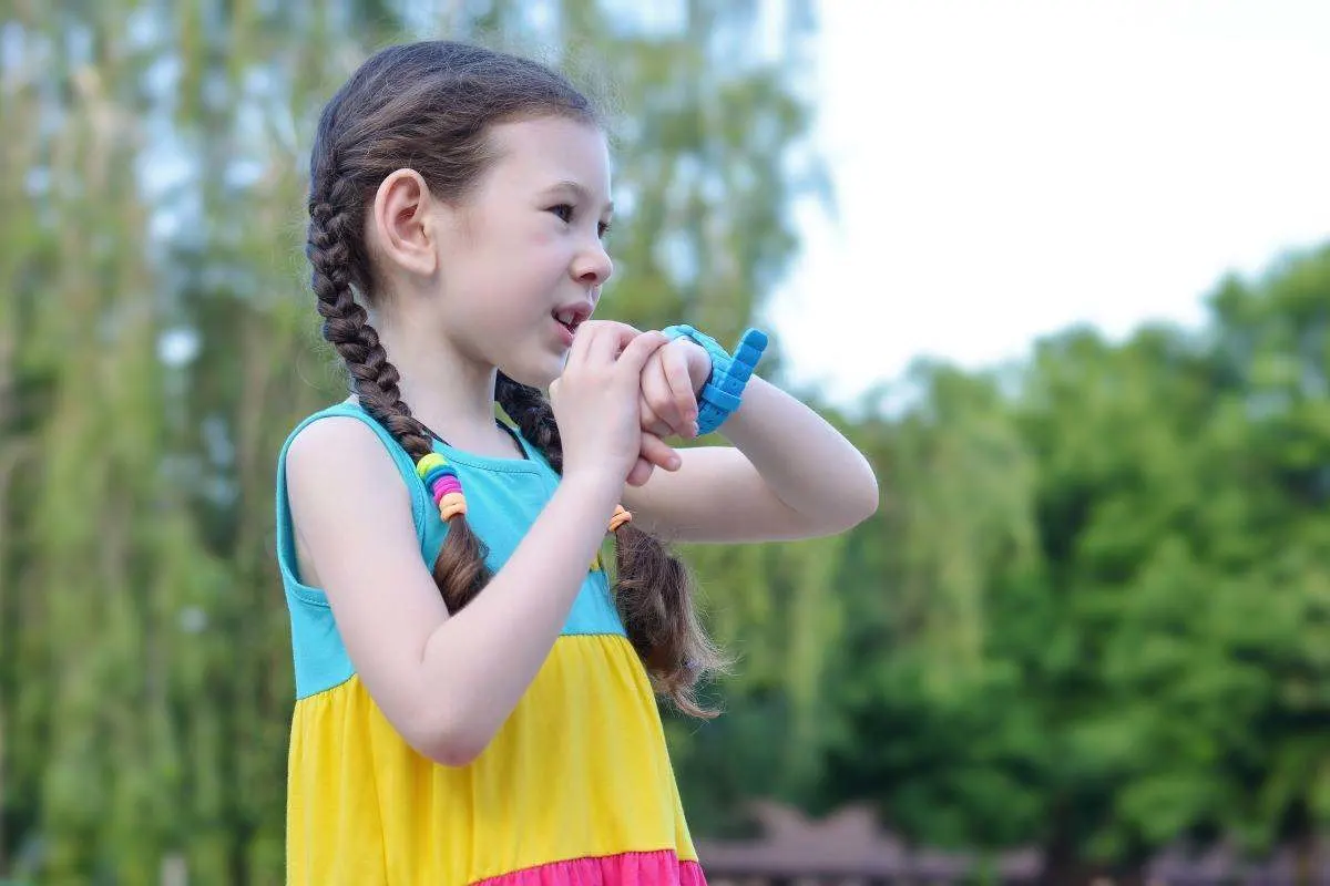 Una bambina parla in un orologio-telefono per bambini al polso