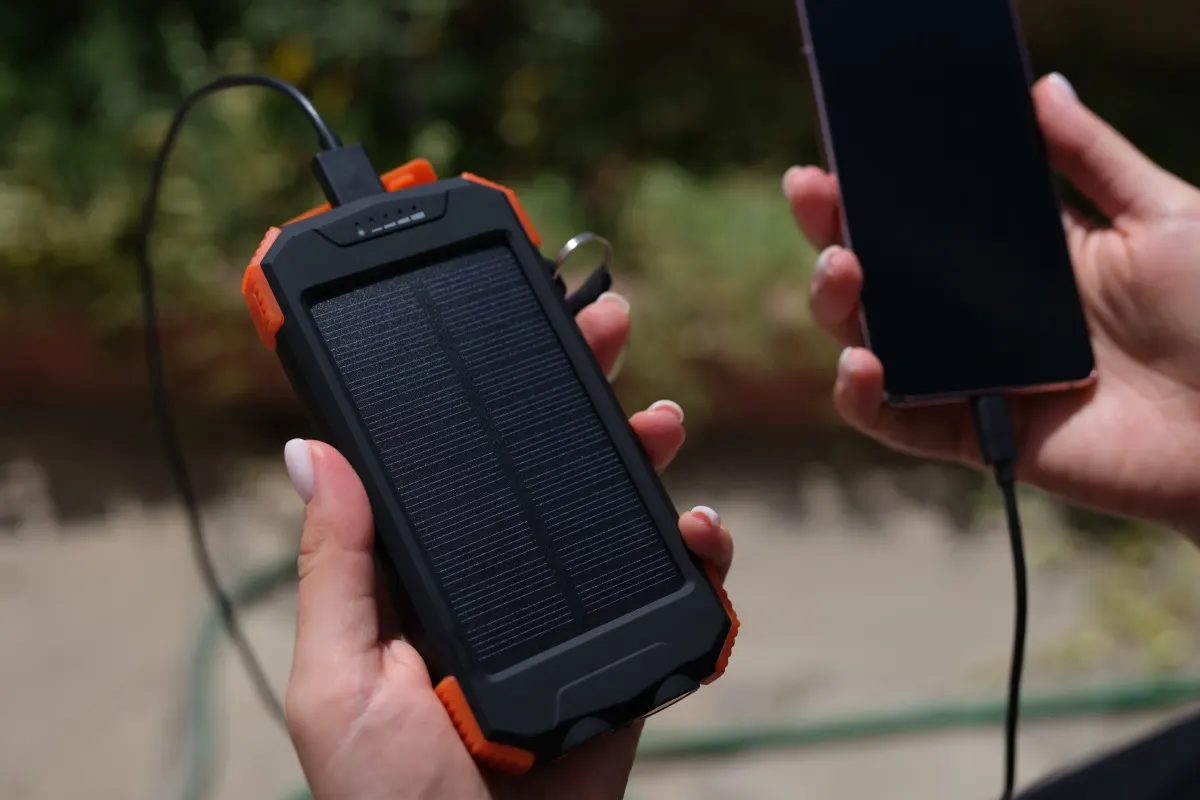 Solar-Powerbank lädt ein Smartphone im Freien.