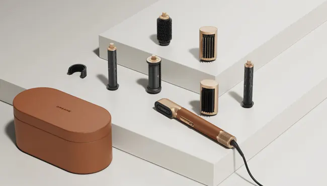 Une boîte marron ovale, divers accessoires de coiffure et un outil de coiffure, sur une surface blanche étagée.