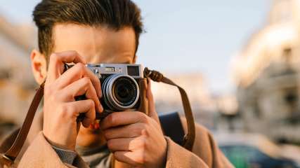 Mann schießt ein Foto mit einer Digitalkamera.