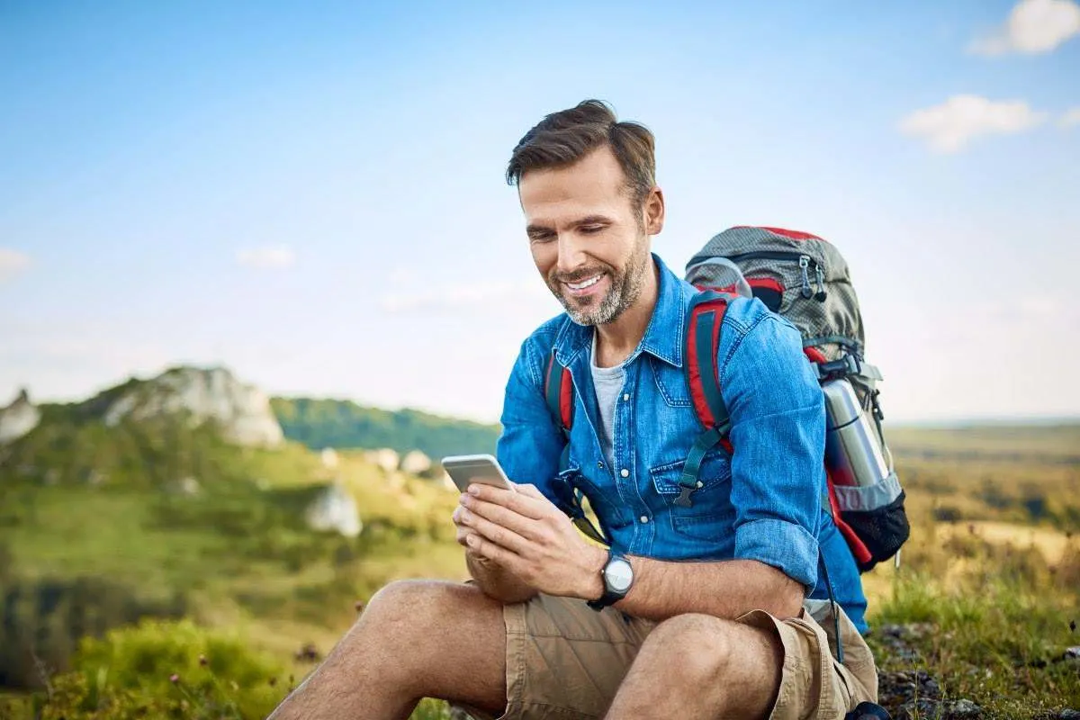 Un escursionista guarda lo smartphone durante una pausa.