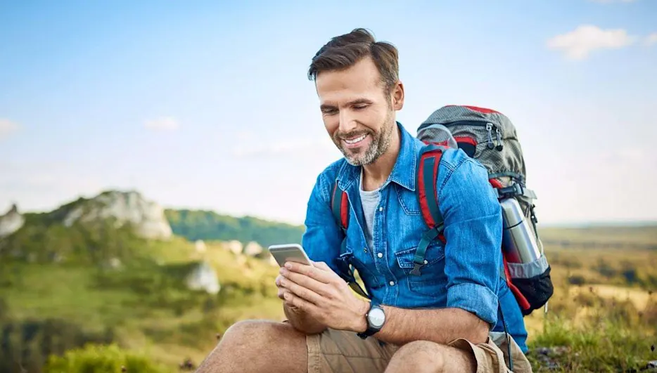 Un escursionista guarda lo smartphone durante una pausa.