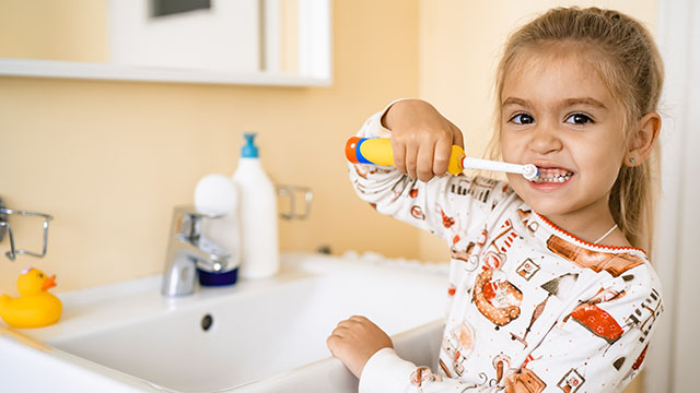 Enfant avec brosse à dents électrique