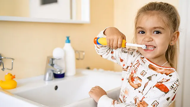 Enfant avec brosse à dents électrique