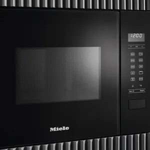 Four à micro-ondes noir intégré avec écran numérique, boutons de commande et logo Miele en bas à gauche.
