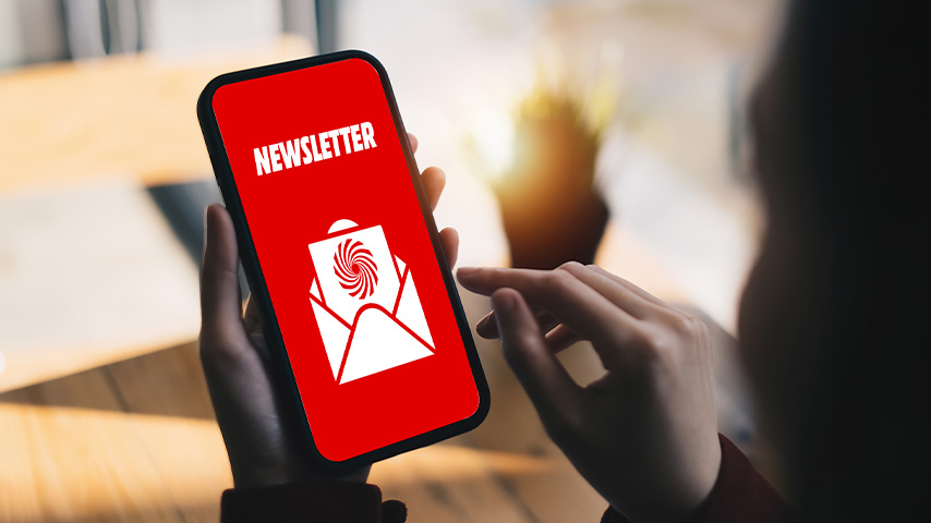 Eine Person hält ein Smartphone mit rotem Bildschirm, auf dem "Newsletter" und ein Briefsymbol angezeigt werden.