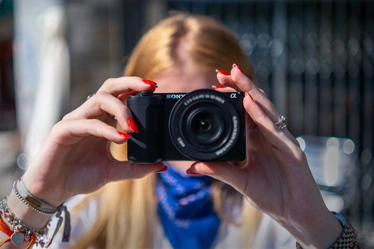 Donna che fotografa con una Sony ZV-E10 II. 