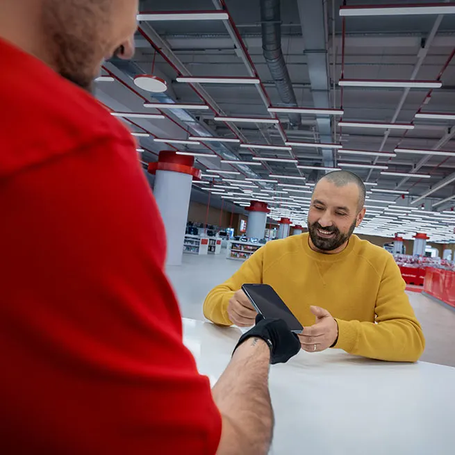 Ein MediaMarkt-Mitarbeiter bedient einen Kunden an der Smartbar