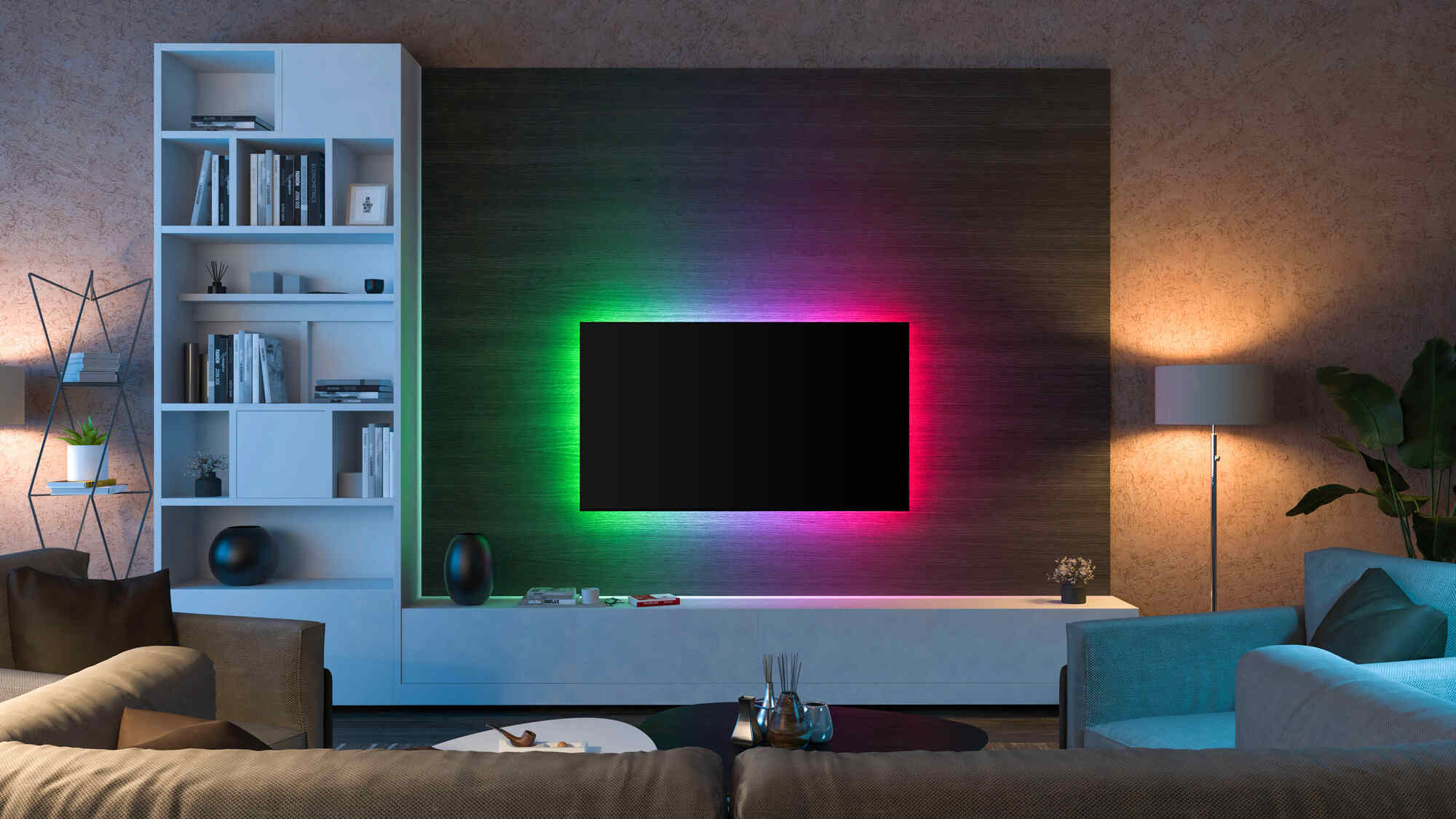 Soggiorno con TV a muro e illuminazione Ambilight colorata in verde, blu e rosa dietro lo schermo.