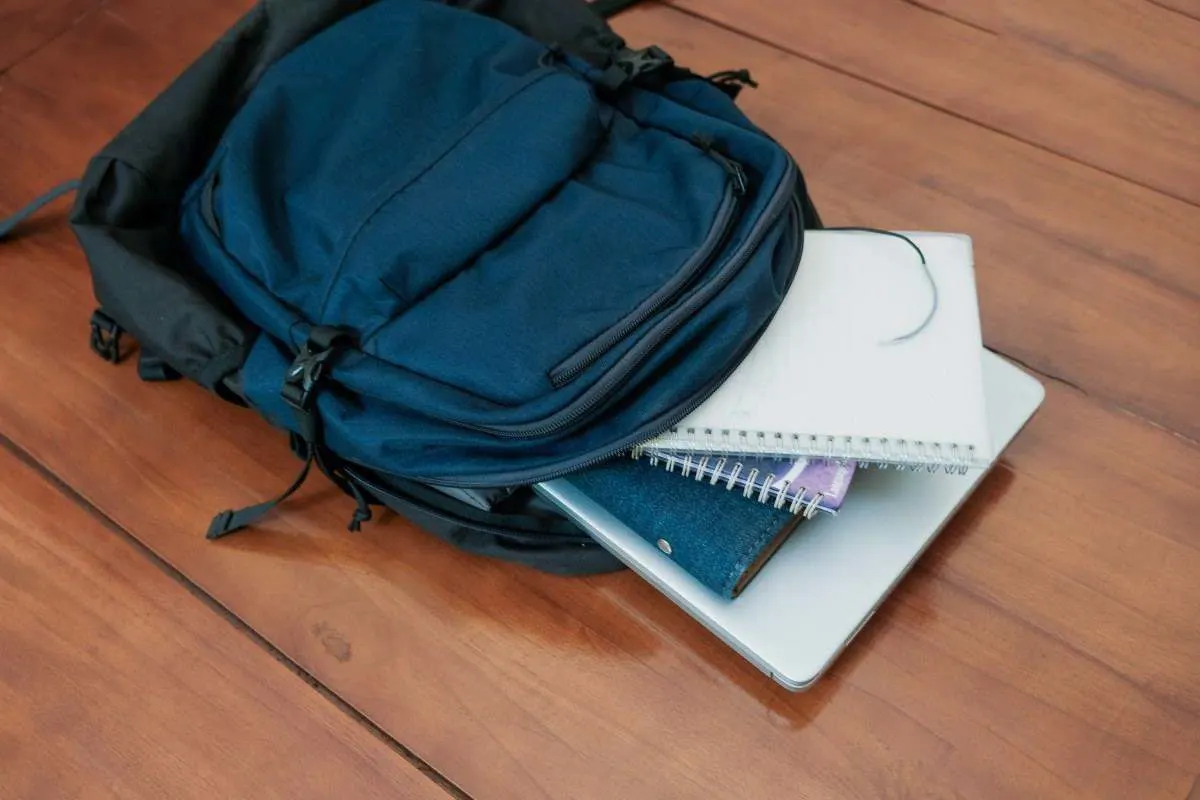 Un sac d'école avec un laptop et des cahiers montre ce qui compte pour un laptop mobile destiné aux élèves.