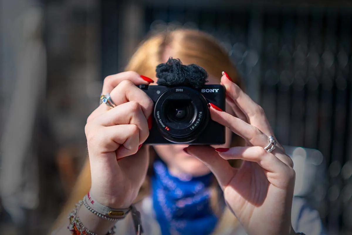 Donna che fotografa con una Sony ZV-1 II. 