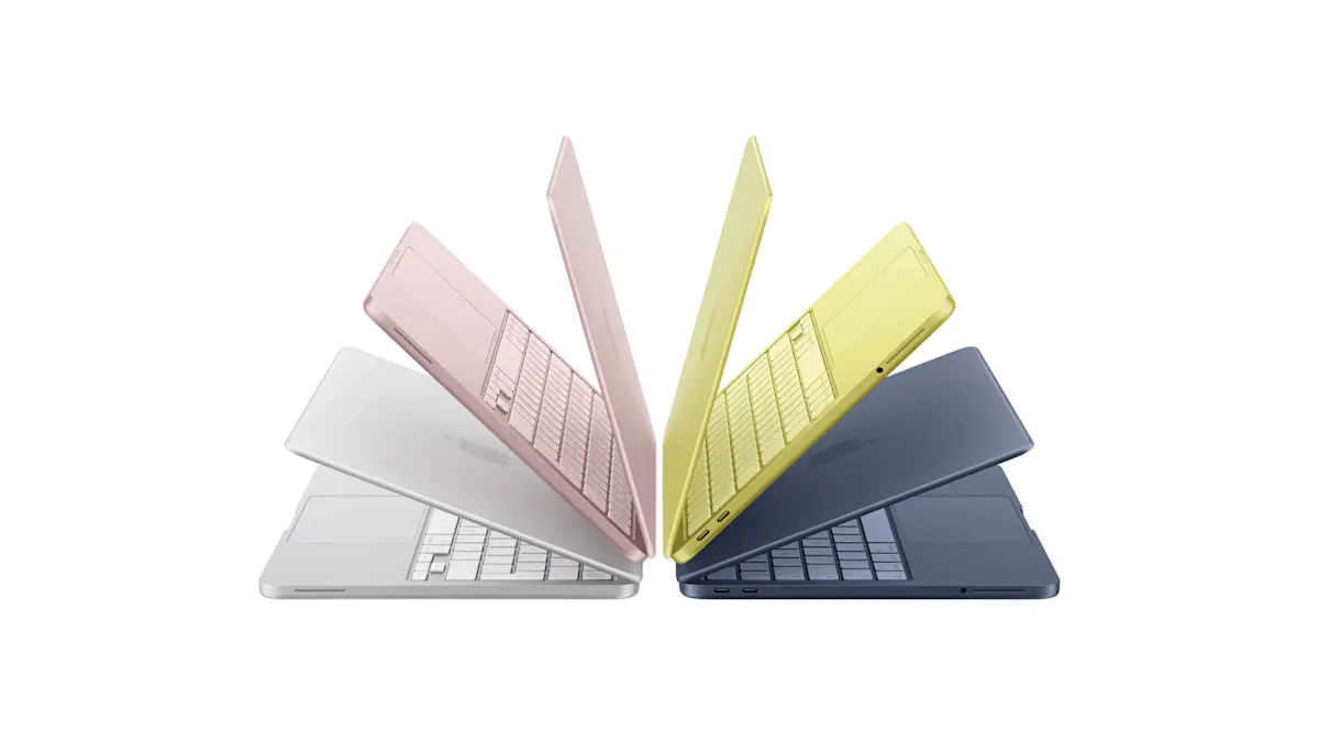 Vier MacBook Neo in Rosa, Indigo, Silber und Zitrus halb geöffnet, in einem Halbkreis angeordnet wie eine untergehende Sonne. 