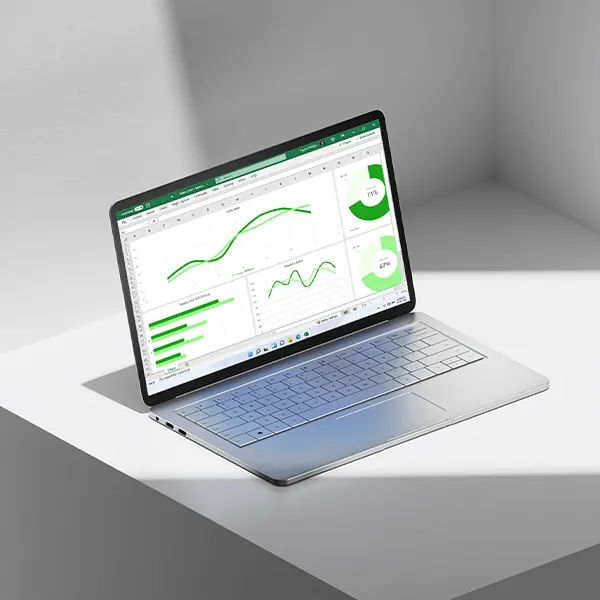 Sur l'écran d'un ordinateur portable argenté s'affiche un tableau Excel avec différents diagrammes et tableaux verts.