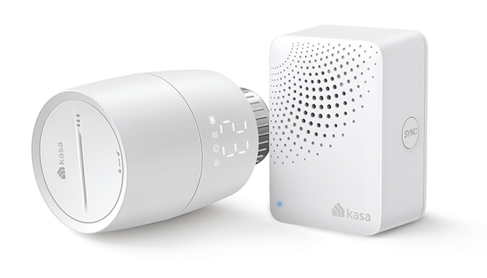 Ein weißer, zylindrischer Thermostat liegt neben einer weißen, würfelförmigen Basisstation mit Löchern und dem Kasa-Logo.