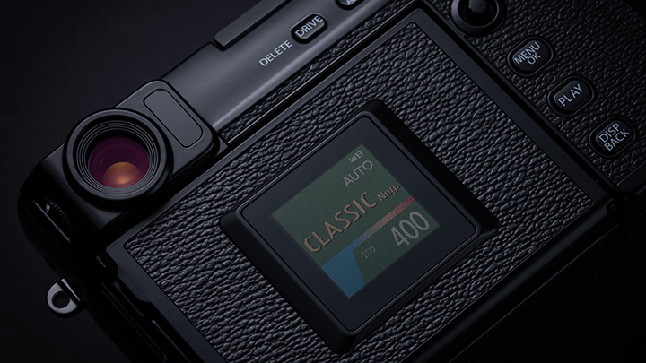 Nahaufnahme einer schwarzen Kamera mit Bildschirm, auf dem "Classic 400" steht, und Knöpfen für "Delete", "Drive", "Menu", "Play" und "Disp Back".