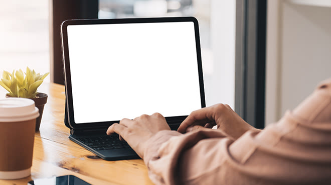 Frau verwendet iPad mit einer Hülle mit Tastatur