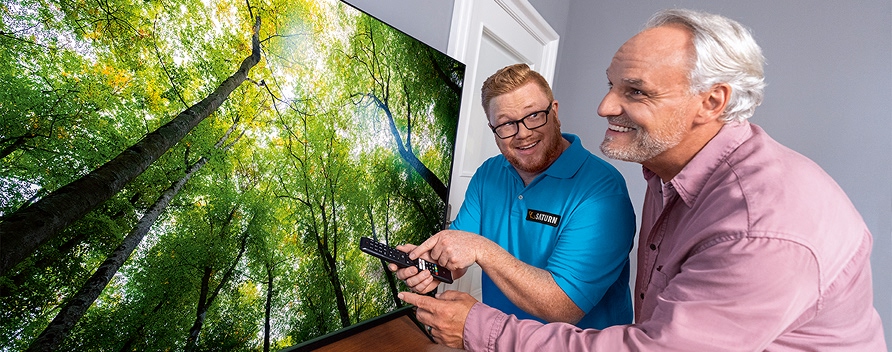 Mitarbeiter zeigt Kunden die Vorteile der TV-Kalibrierung.