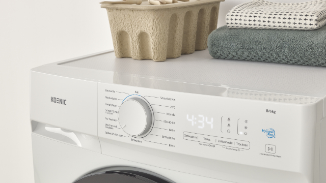 Επάνω μέρος του πλυντηρίου-στεγνωτηρίου KOENIC KWDR 8642 A INV με πίνακα ελέγχου, καλάθι και πετσέτες.