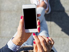 Eine Frau tippt auf ihrem weißen iPhone.