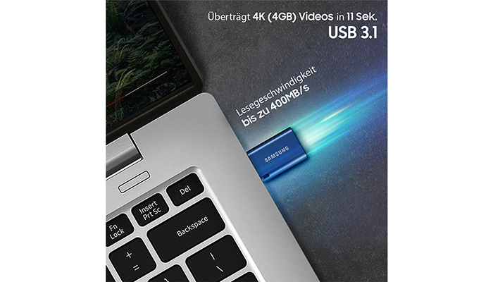Nahaufnahme eines silbernen Laptops mit einer blauen Samsung USB 3.1 SSD. Text: "Überträgt 4K (4GB) Videos in 11 Sek. Lesegeschwindigkeit bis zu 400MB/s."