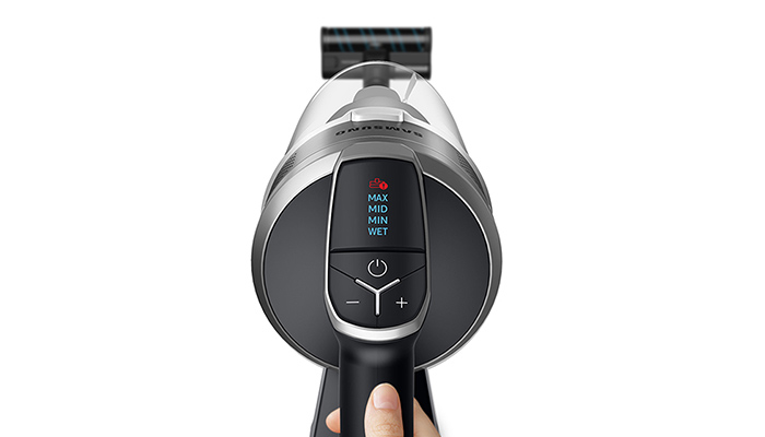 Ein grauer Samsung Staubsauger mit einem schwarzen Griff und einem Display mit 'MAX', 'MID', 'MIN' und 'WET' Einstellungen.