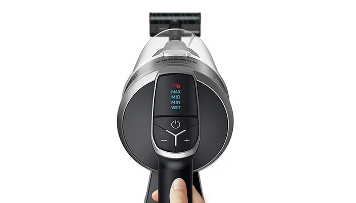 Ein grauer Samsung Staubsauger mit einem schwarzen Griff und einem Display mit 'MAX', 'MID', 'MIN' und 'WET' Einstellungen.