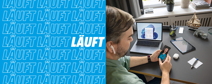 Ein Mann sitzt an einem Schreibtisch mit Laptop, Tablet, Stiften und Dekoration. Er hält ein Smartphone in den Händen. Links steht "LÄUFT".
