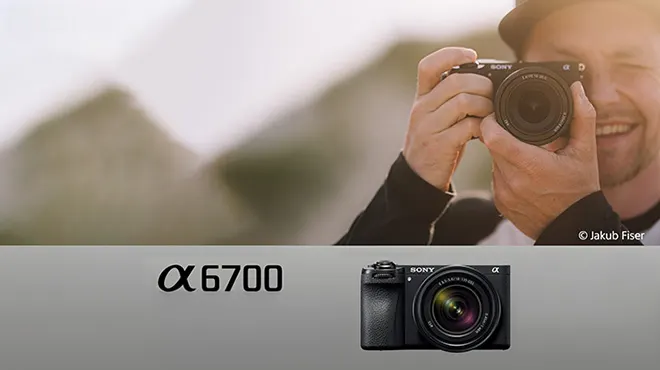 Ein Mann hält eine Sony Kamera vor einem unscharfen Hintergrund. Unten befindet sich eine Nahaufnahme der Kamera und der Text "Sony α 6700".