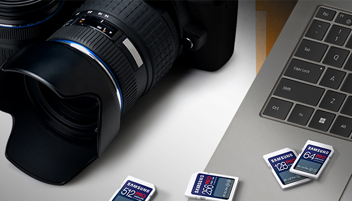 Nahaufnahme einer Spiegelreflexkamera und eines Laptops. Darauf liegen mehrere Samsung Speicherkarten.