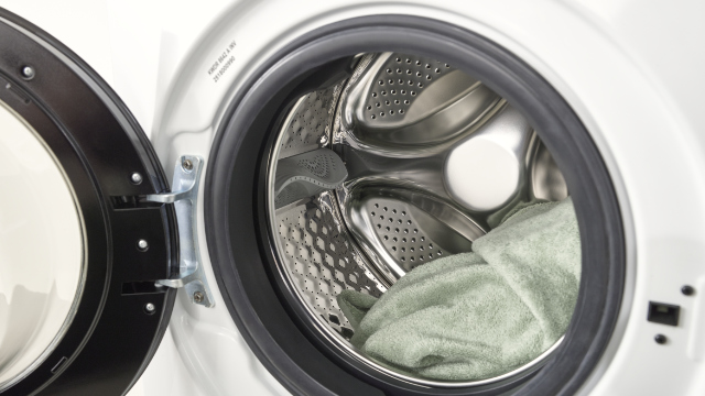 Κοντινό πλάνο του ανοιχτού κάδου πλυσίματος του KOENIC KWDR 8642 A INV με ρούχα στο εσωτερικό.