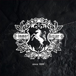 Weißes Emblem auf dunklem Grund: Pferd, umgeben von Blättern und Schriftzug "Immer Besser" und "since 1899".