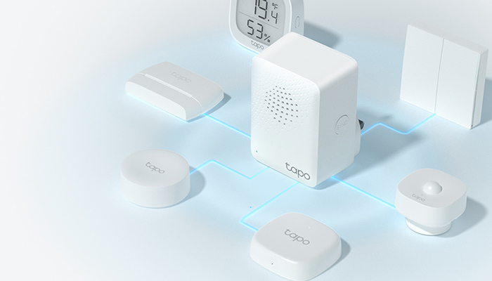 Auf einem hellen Hintergrund sind verschiedene weiße Smart-Home-Geräte und ein digitaler Wecker angeordnet. Blaue Linien verbinden die Geräte.