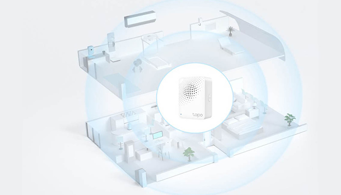 Ein transparentes, zweistöckiges Hausmodell mit Möbeln und einem runden Symbol, das ein weißes, rechteckiges Gerät zeigt.