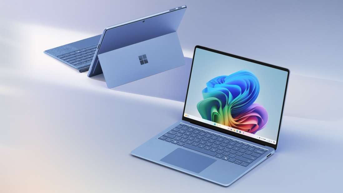 Auf hellem Grund stehen zwei blaue Laptops, einer geöffnet mit buntem Bild, der andere geschlossen und aufgestellt.