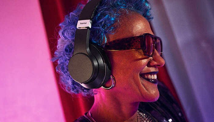 Trendige Musikliebhaberin /blaue Haare) mit einem Hama Kopfhörer beim Genuss ihres Lieblingscontents.