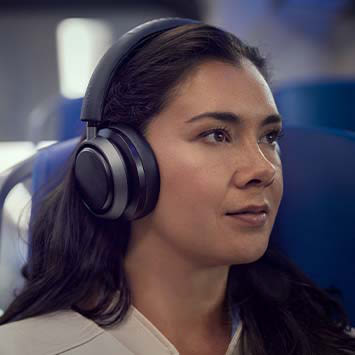Eine Frau hat Over-ear-Kopfhörer aufgesetzt.