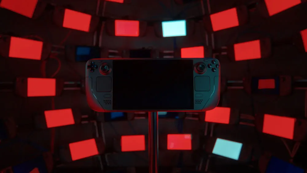 Ein Steam Deck wird auf einem Ständer vor einer Wand aus roten und blauen Leuchtkästen präsentiert.