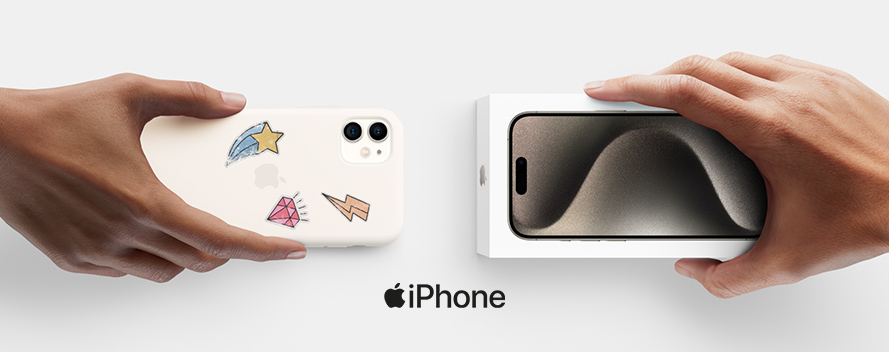 Zwei Hände halten ein iPhone mit Aufklebern und eine iPhone-Verpackung vor einem weißen Hintergrund. Das Apple Logo ist sichtbar.