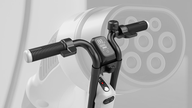 Nahaufnahme von E-Scooter-Lenker mit Digitalanzeige. Im Hintergrund ist eine undeutliche Ladestation zu sehen.