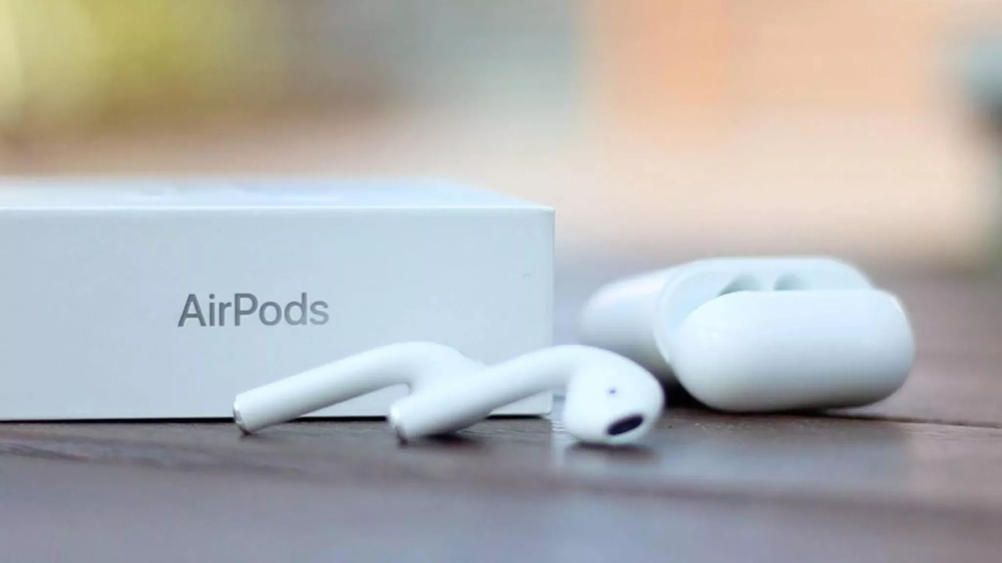 AirPods liegen neben dem dazugehörigen Ladecase und der Verpackung.